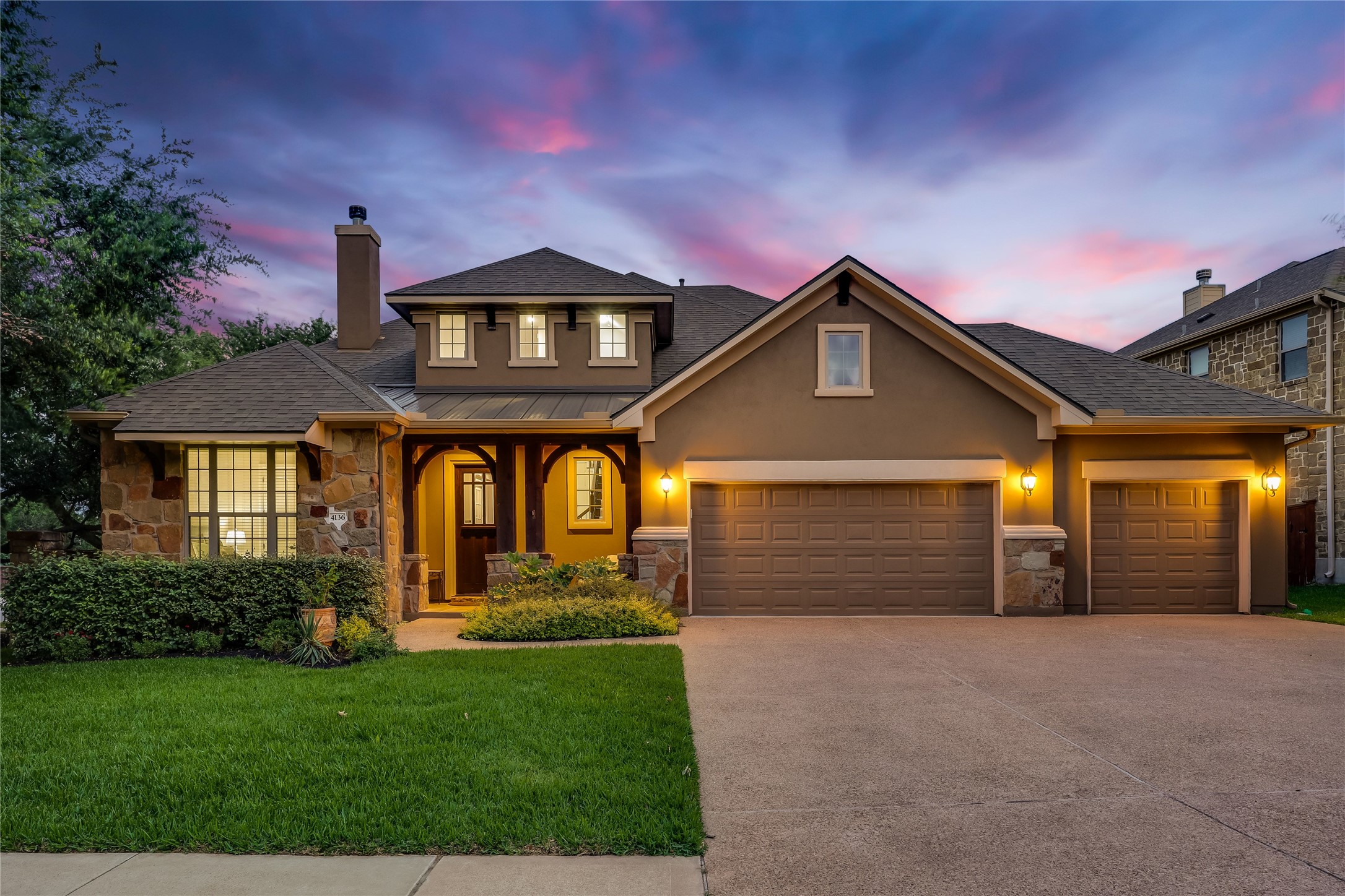 4136 Remington Road Cedar Park, TX 78613 - Photo 1 of 1 Stone and stucco create an appealing façade, illuminated by warm exterior lights under a vivid twilight sky.