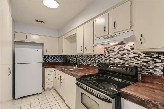 a kitchen with appliances cabinets and a stove top oven