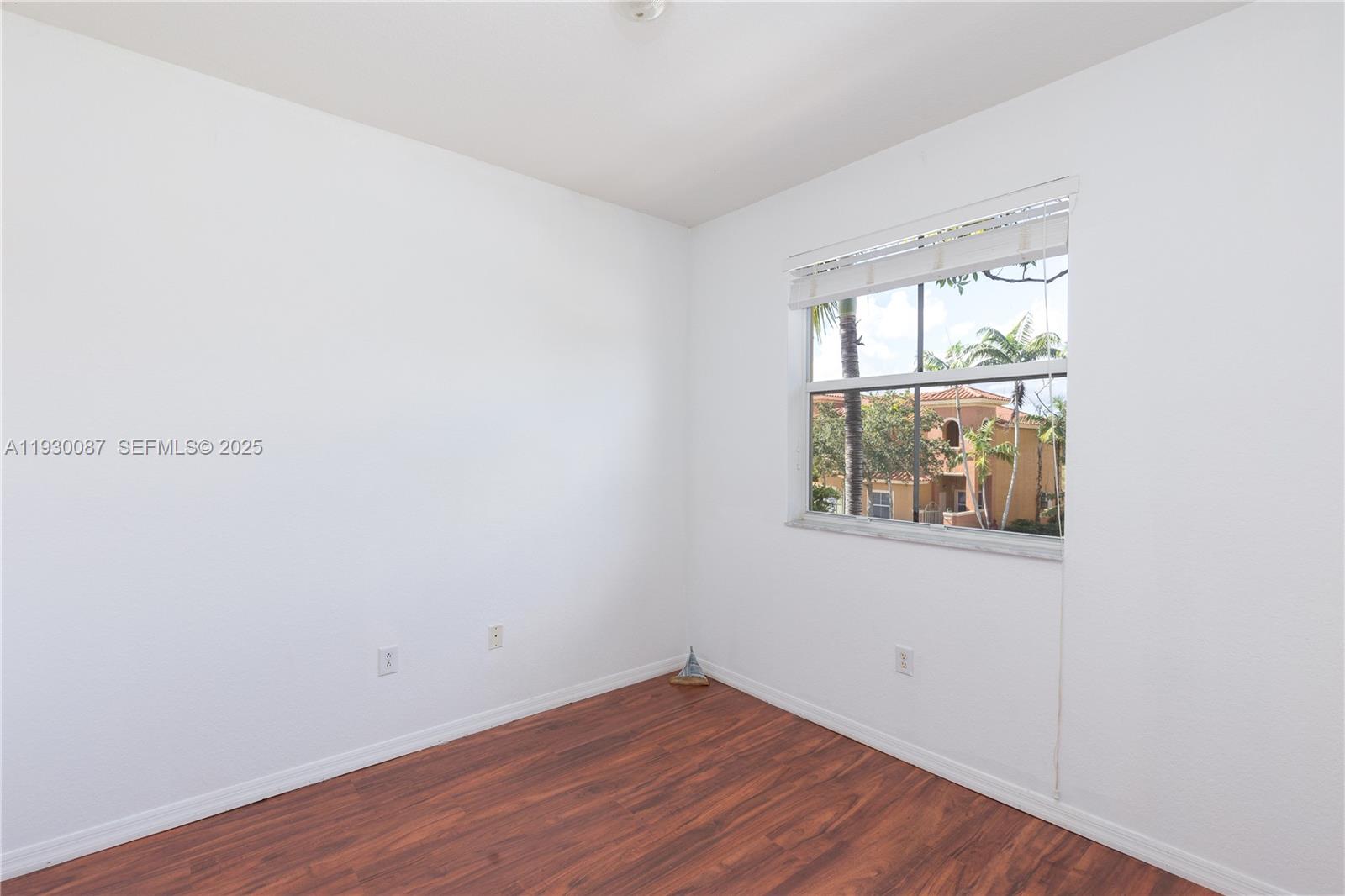 1009 Southwest 144th Avenue, Unit 2701 Pembroke Pines, FL 33027 - Photo 18 of 36 an empty room with wooden floor and windows