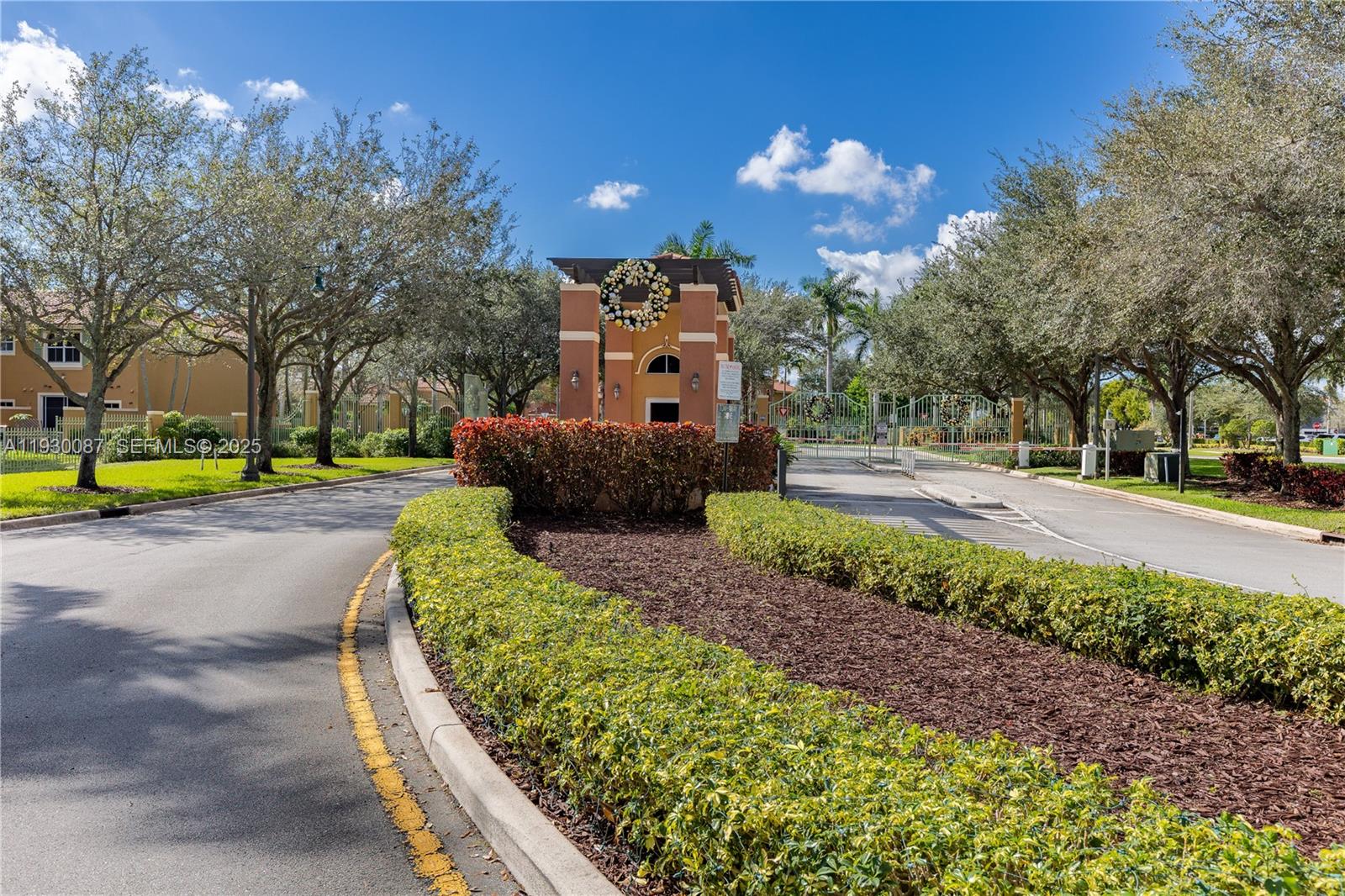 1009 Southwest 144th Avenue, Unit 2701 Pembroke Pines, FL 33027 - Photo 23 of 36 a sign board with a big yard and large trees