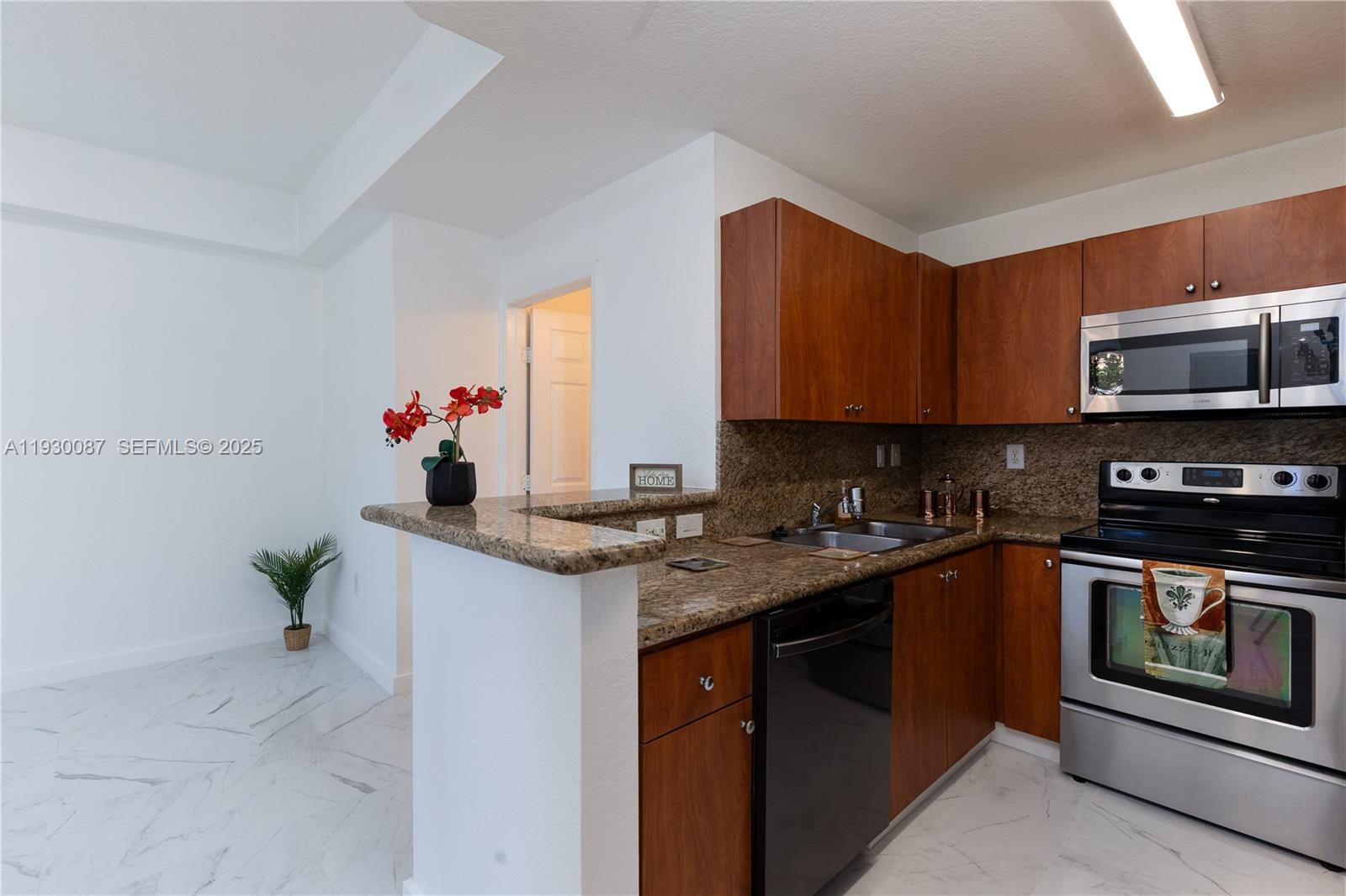 1009 Southwest 144th Avenue, Unit 2701 Pembroke Pines, FL 33027 - Photo 5 of 36 a kitchen with stainless steel appliances granite countertop a stove a sink and a microwave