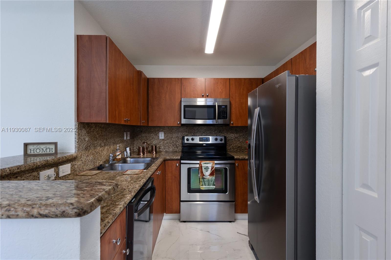 1009 Southwest 144th Avenue, Unit 2701 Pembroke Pines, FL 33027 - Photo 6 of 36 a kitchen with stainless steel appliances granite countertop a sink stove and refrigerator