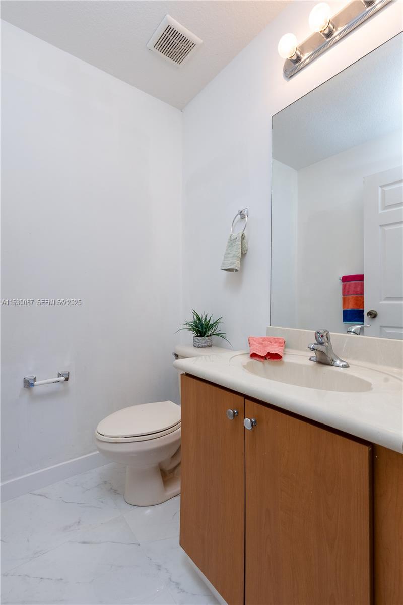 1009 Southwest 144th Avenue, Unit 2701 Pembroke Pines, FL 33027 - Photo 9 of 36 a bathroom with a sink toilet and vanity