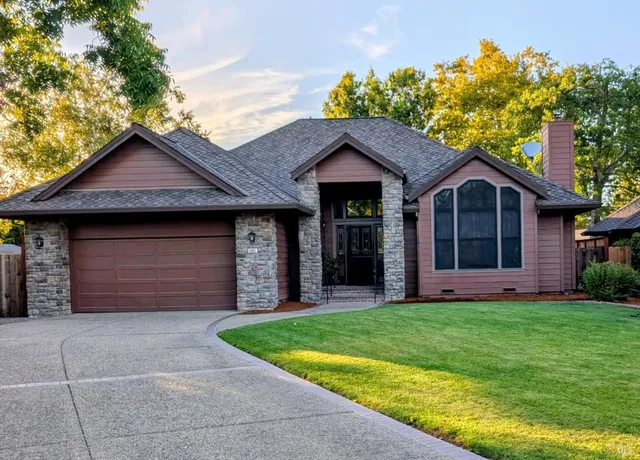 a front view of a house with a garden and yard