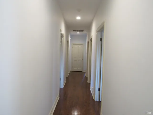 a view of a hallway with wooden floor