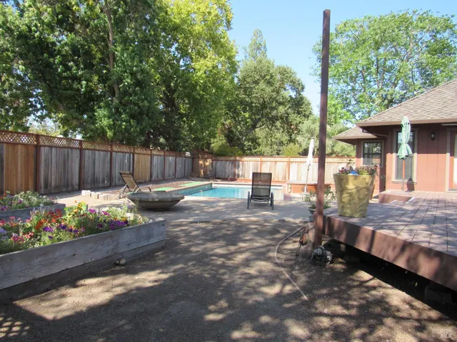 a view of a backyard with table and chairs and potted plants