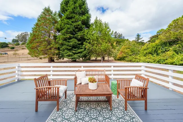 a balcony with wooden floor and outdoor seating