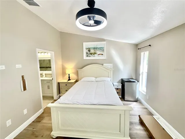 a bedroom with a bed and a table with wooden floor