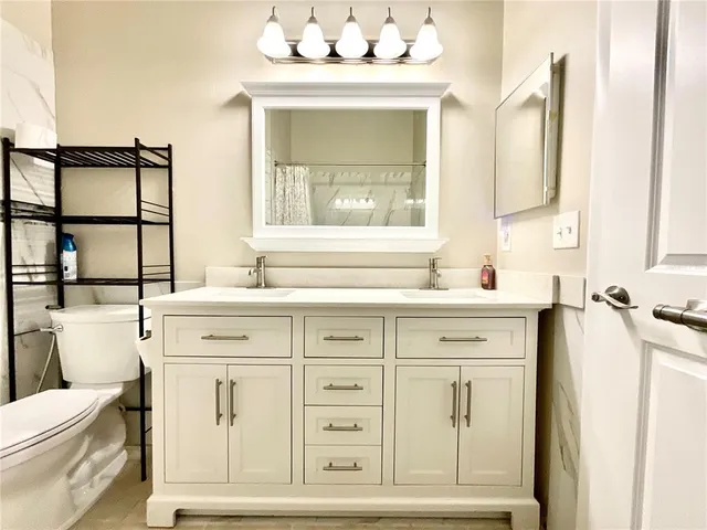 a bathroom with a sink a toilet and a mirror