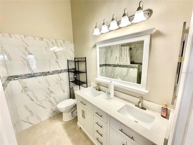 a bathroom with a sink vanity mirror and toilet