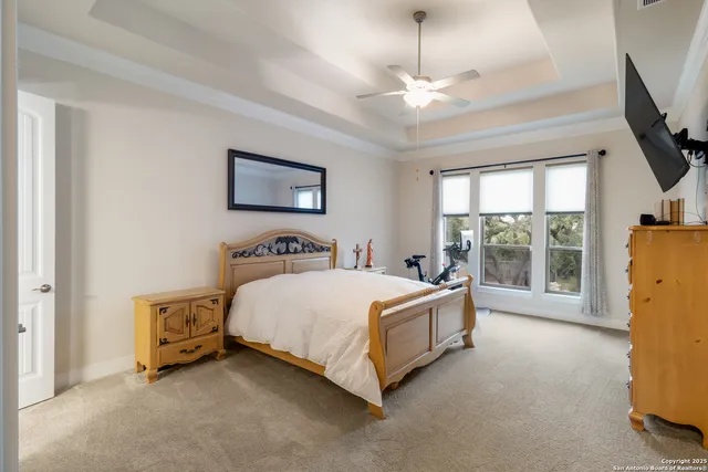 a spacious bedroom with a bed and a flat screen tv