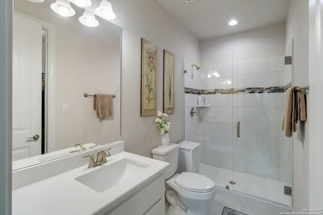 a bathroom with a sink a toilet and shower