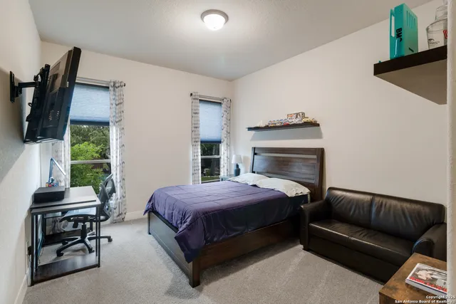 a bedroom with a bed a flat screen tv and dresser