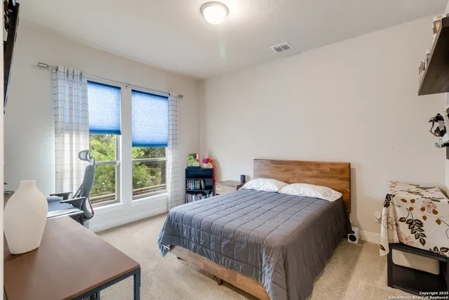 a bedroom with a bed and large windows