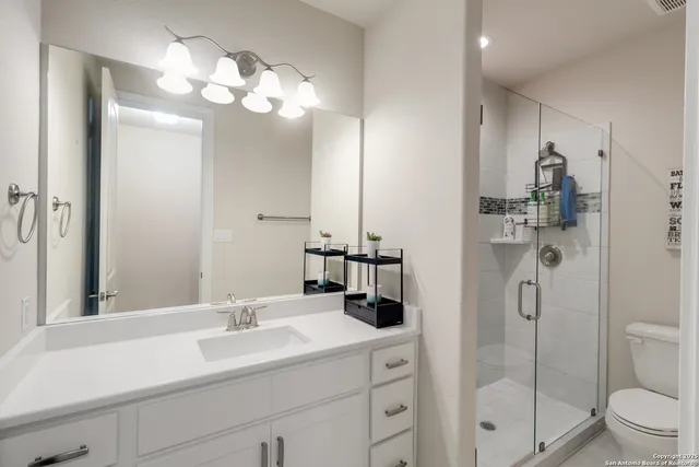 a bathroom with a sink a toilet and shower