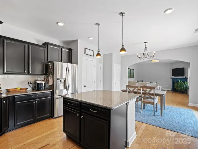 a kitchen with stainless steel appliances granite countertop sink stove top oven and refrigerator