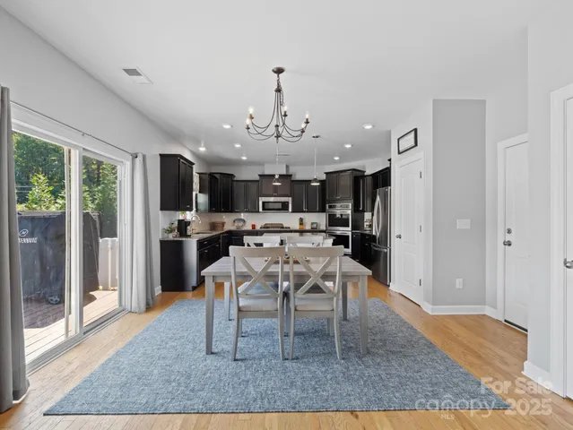 a dining room with stainless steel appliances granite countertop a rug a stove and a refrigerator