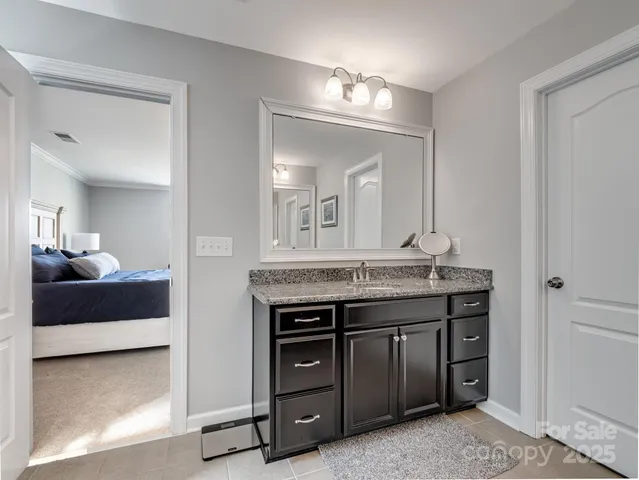 a spacious bathroom with a granite countertop sink a mirror and a vanity