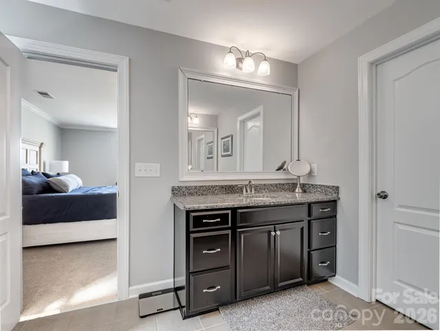a spacious bathroom with a granite countertop sink a mirror and a vanity
