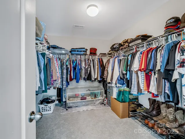 a view of walk in closet with clothes