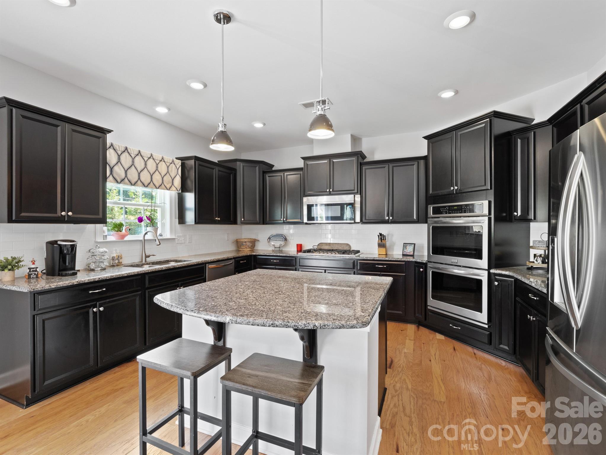 1982 Smokey Quartz Road Davidson, NC 28036 - Photo 6 of 43 a kitchen with kitchen island granite countertop a sink and stainless steel appliances