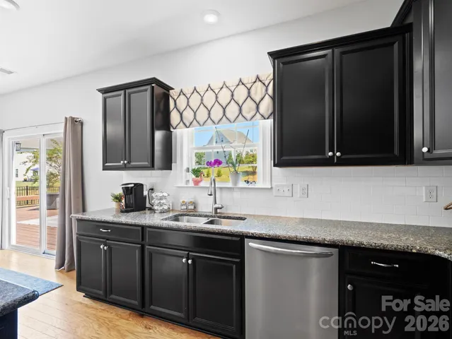 a kitchen with stainless steel appliances granite countertop a sink stove and cabinets