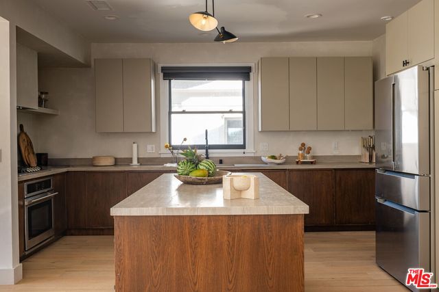 a kitchen with a sink a window cabinets and stainless steel appliances