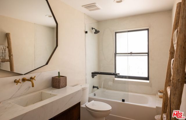 a bathroom with a tub sink and mirror