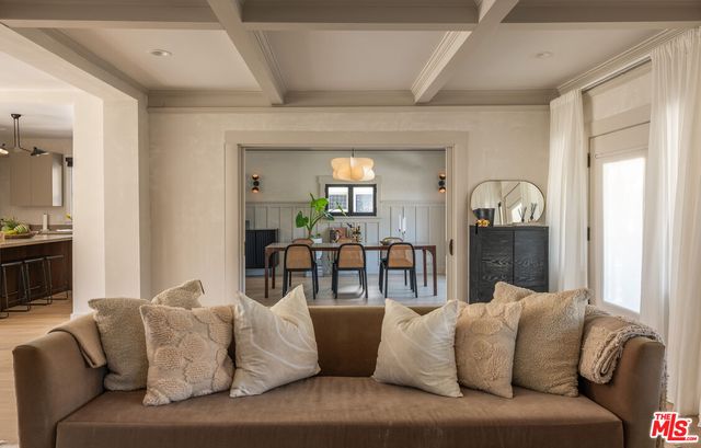 a living room with furniture and a view of kitchen
