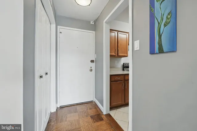 a view of hallway with window and wooden floor