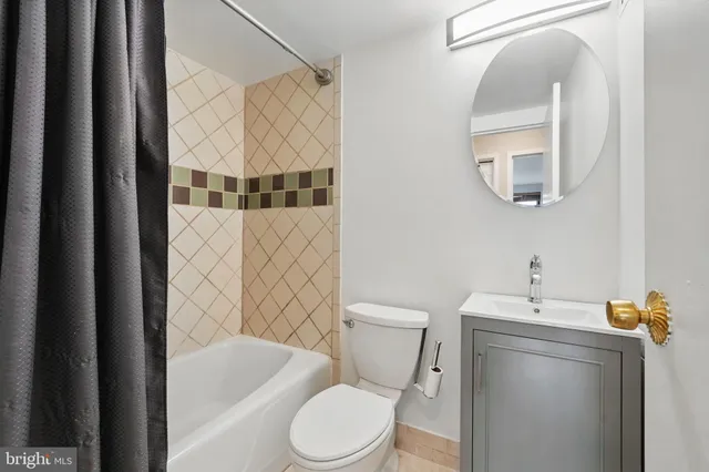 a white toilet sitting next to a bathroom sink and tub