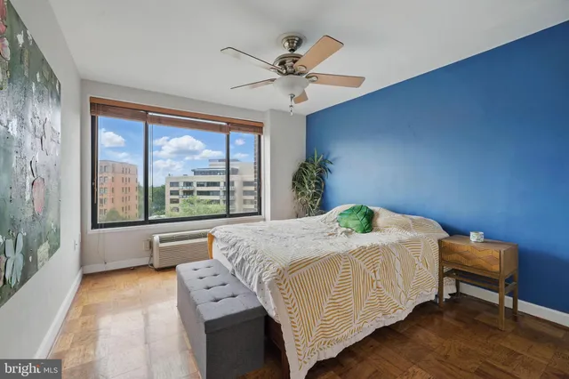 a bedroom with a bed and a large window with outer view