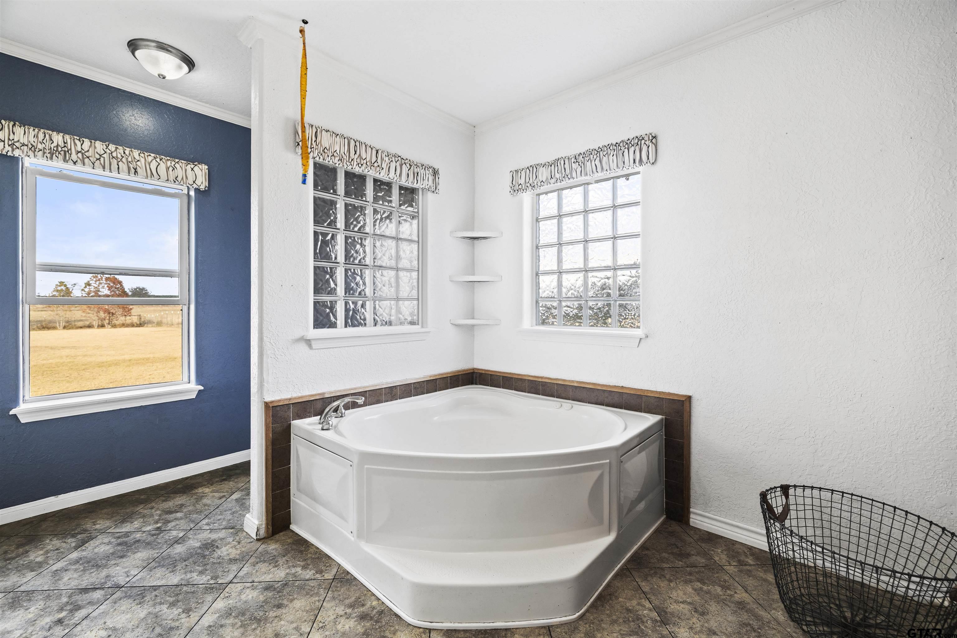 2089 Cottonwood Road Gilmer, TX 75645 - Photo 16 of 30 a bath tub sitting in a bathroom next to a window