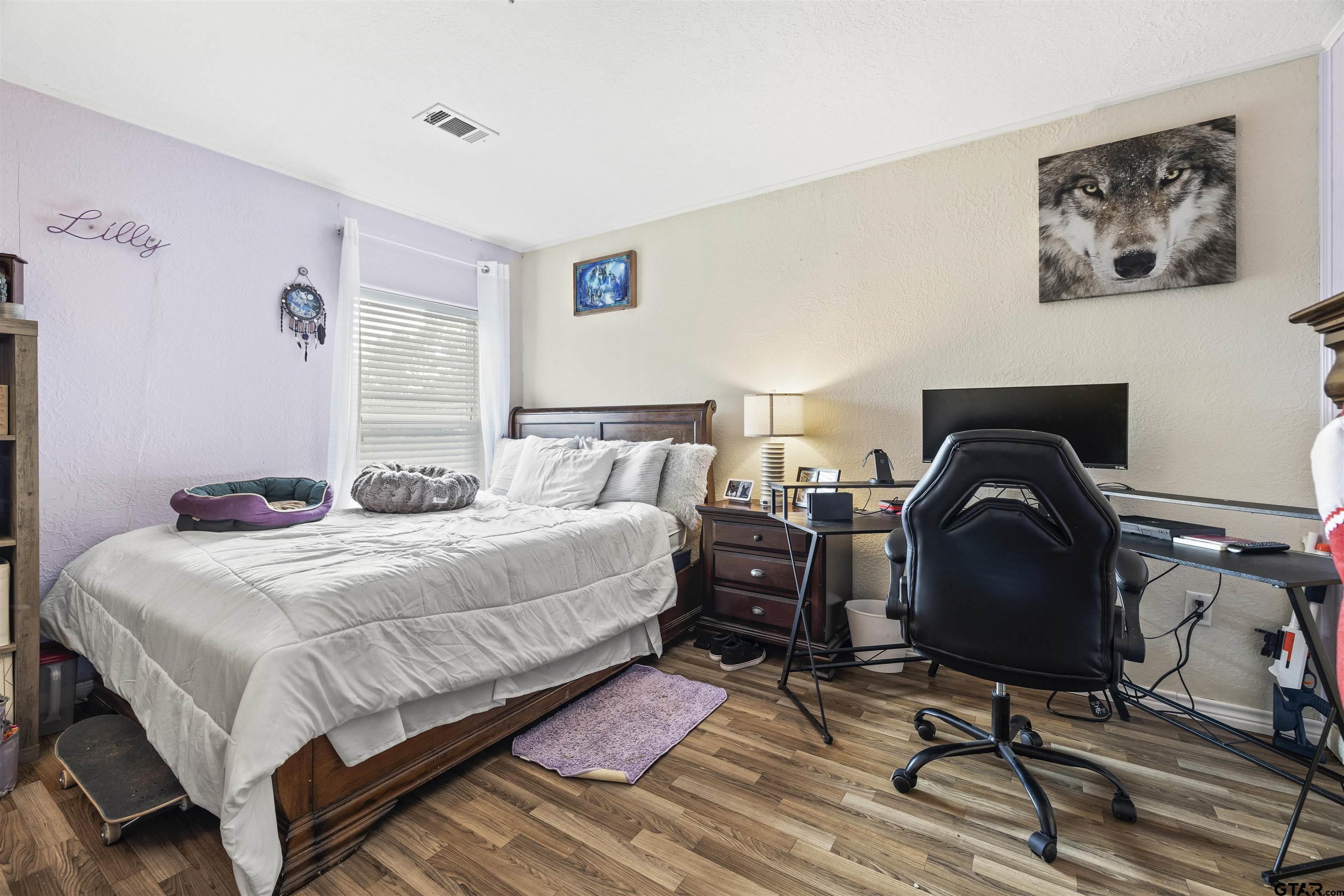 2089 Cottonwood Road Gilmer, TX 75645 - Photo 20 of 30 a bedroom with a bed and a chair with the potted plant