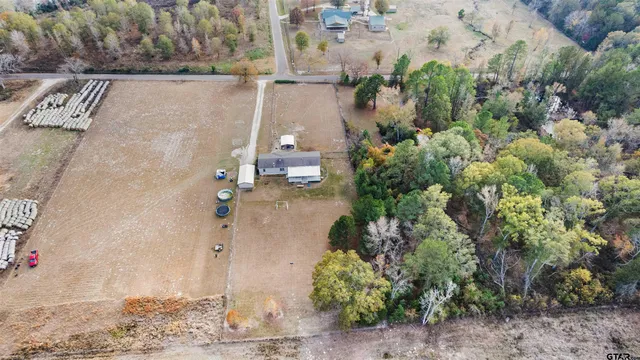 an aerial view of a house with a yard and trees