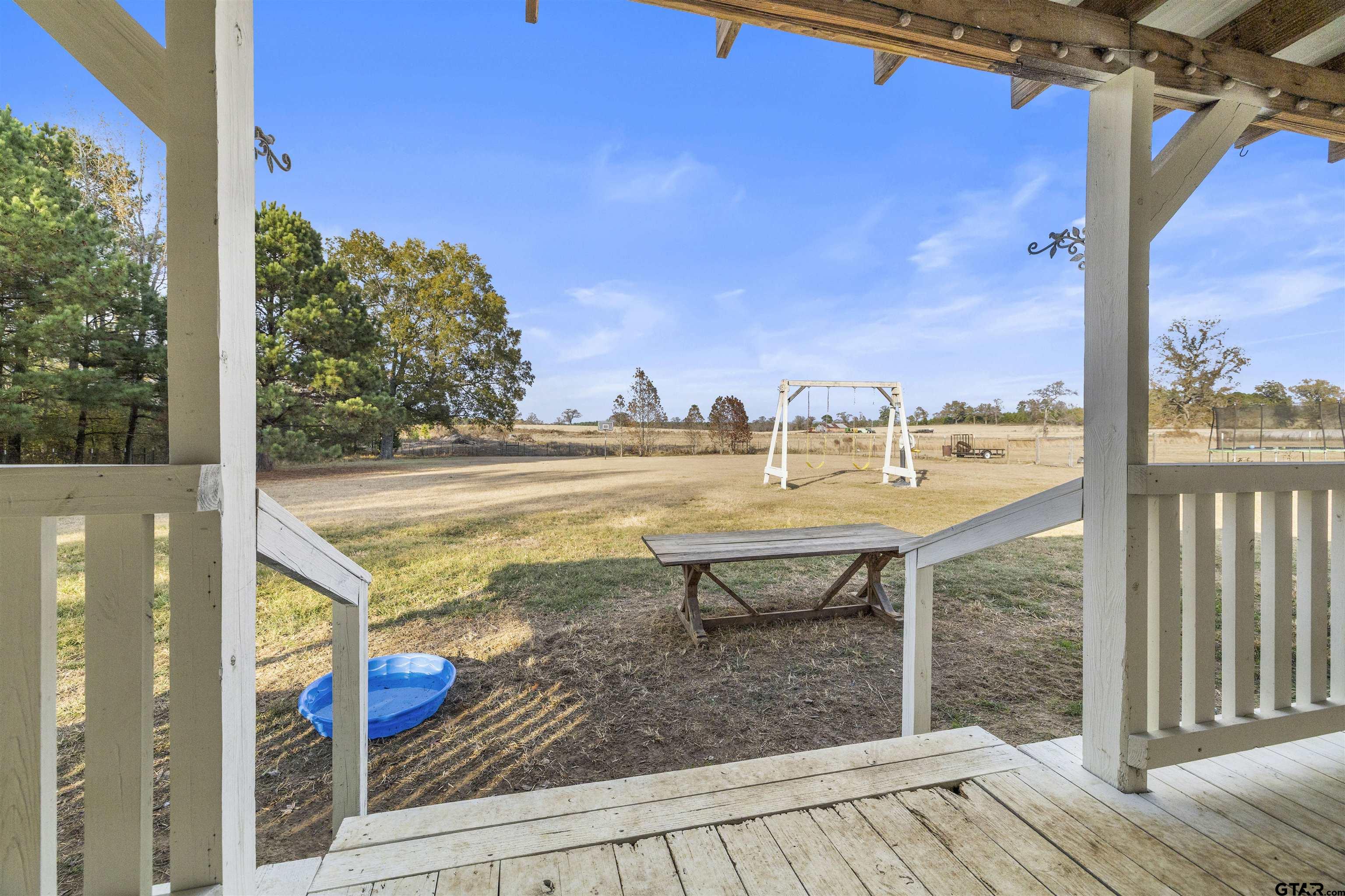 2089 Cottonwood Road Gilmer, TX 75645 - Photo 23 of 30 a view of a balcony with floor to ceiling windows with wooden floor