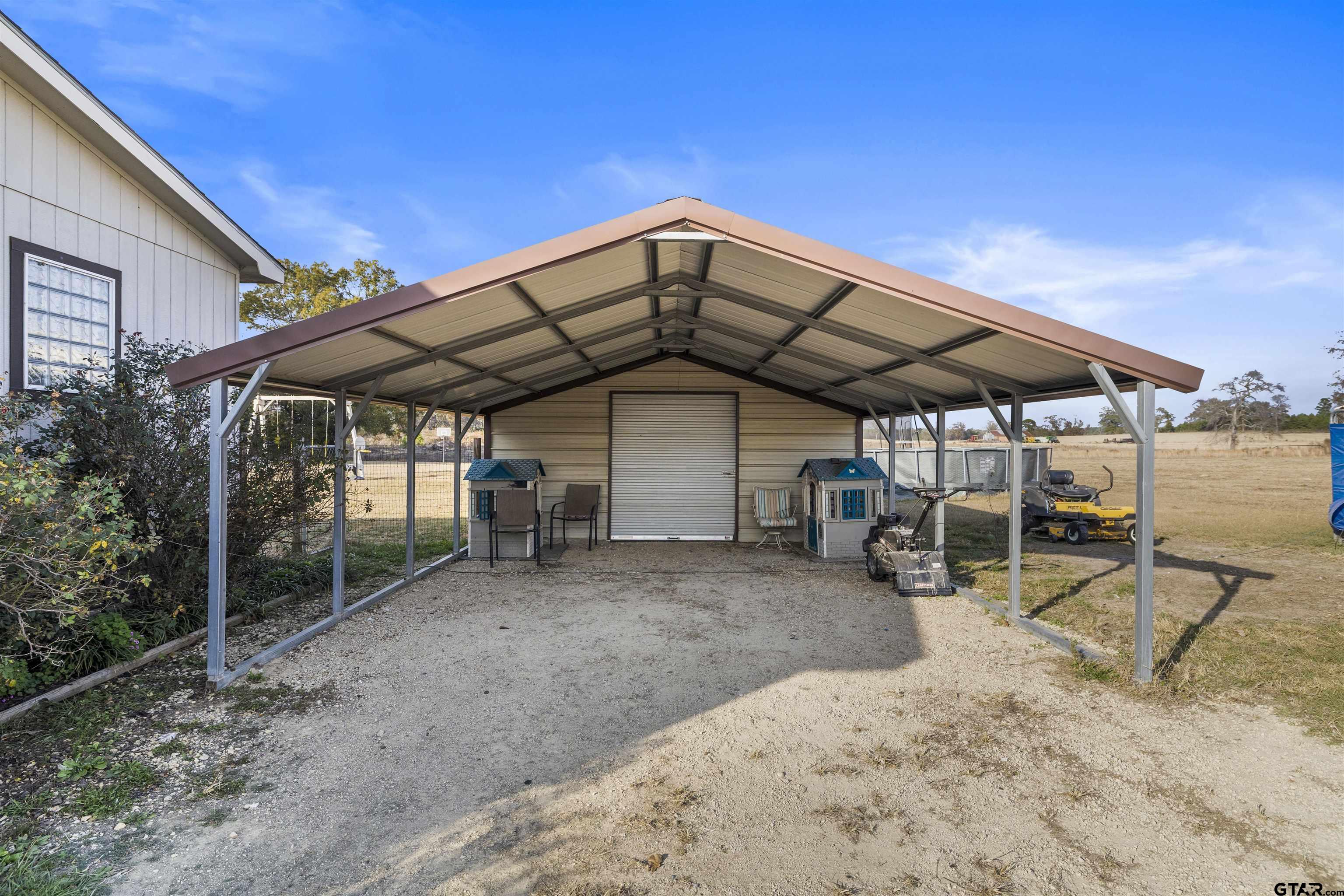 2089 Cottonwood Road Gilmer, TX 75645 - Photo 27 of 30 a view of a chairs and table under an umbrella