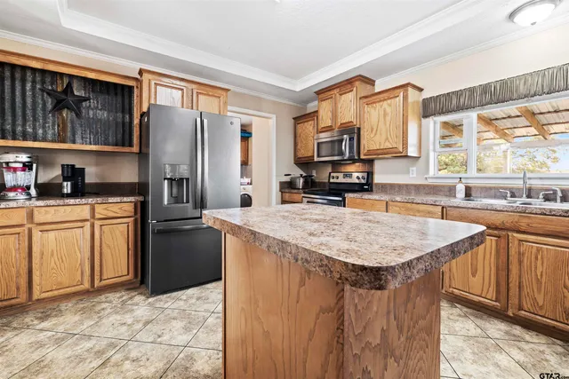 a kitchen with stainless steel appliances granite countertop a refrigerator a stove and a sink