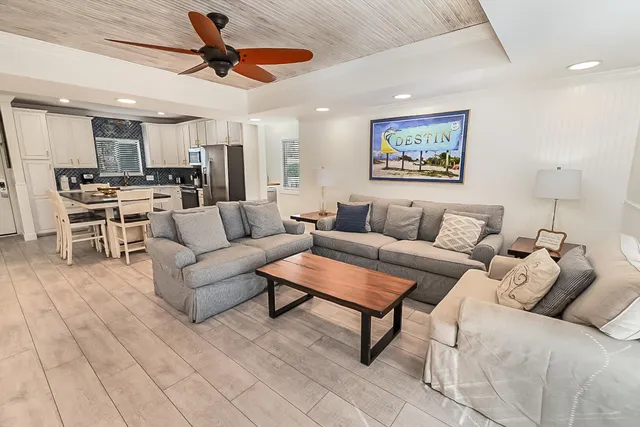 a living room with furniture and a view of kitchen