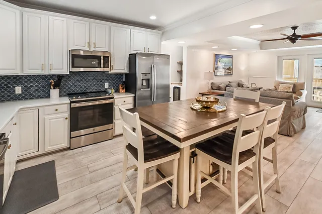a kitchen with granite countertop a stove a table and chairs in it