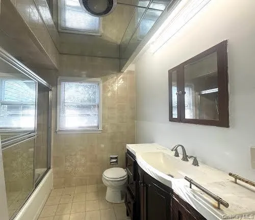 a bathroom with a granite countertop sink a toilet and a mirror