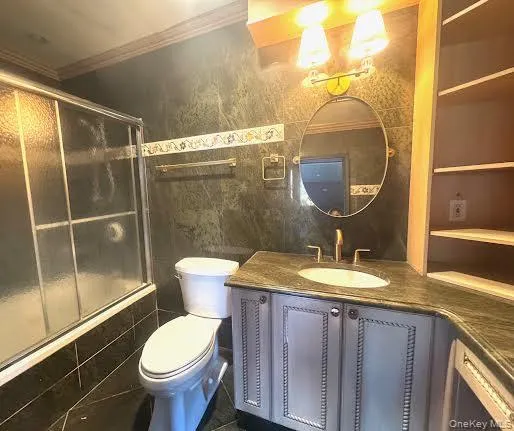 a bathroom with a granite countertop sink mirror vanity and toilet
