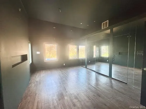 a view of empty room with wooden floor and windows