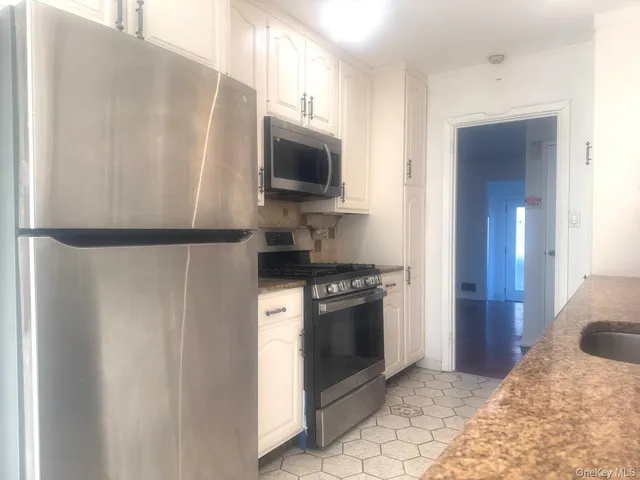 a kitchen with stainless steel appliances granite countertop a refrigerator stove and microwave