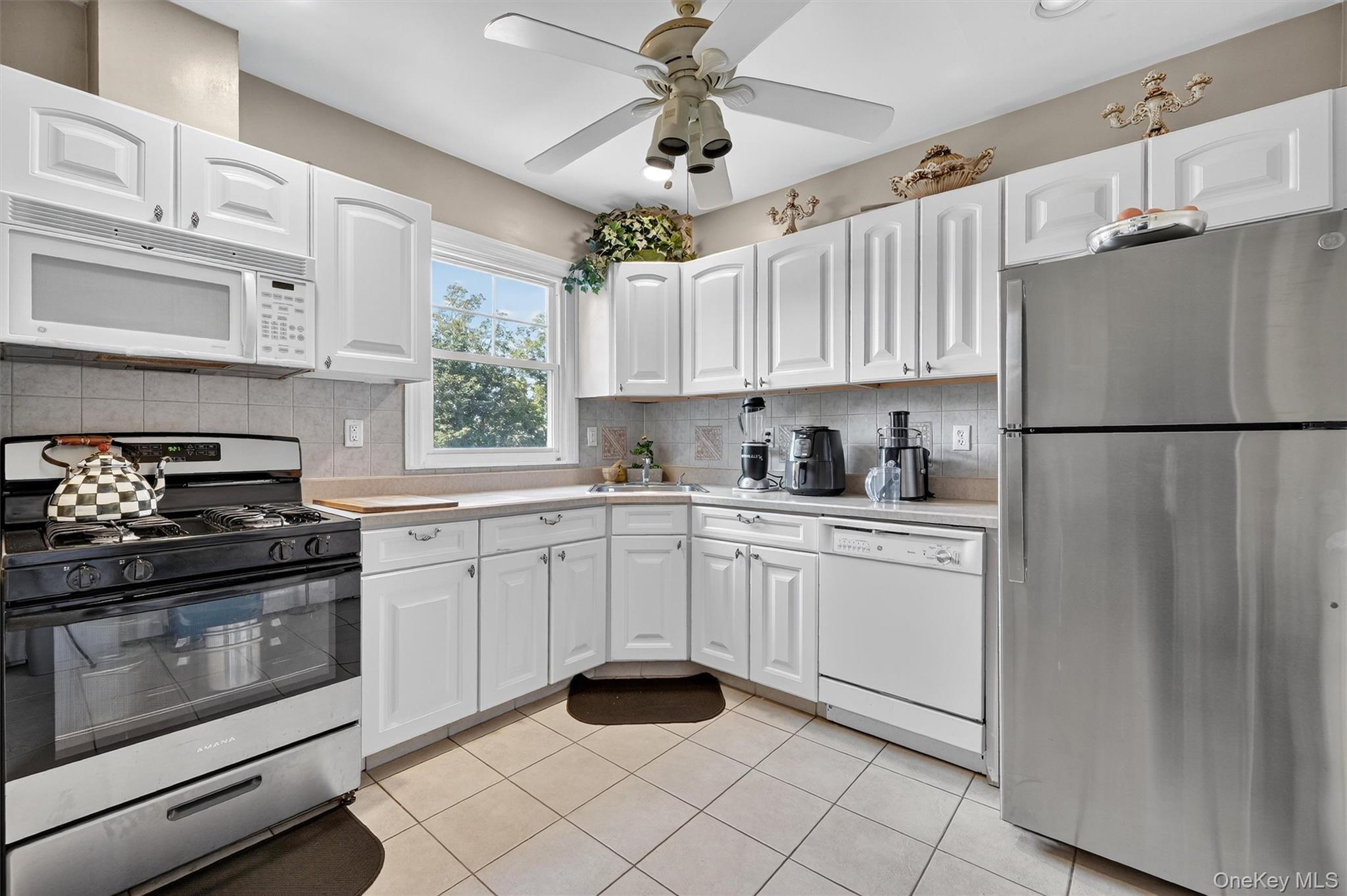 16 Maple Place Ossining, NY 10562 - Photo 21 of 45 a kitchen with granite countertop white cabinets white stainless steel appliances and a refrigerator