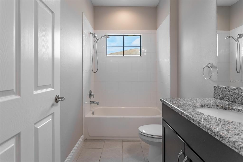 6906 Paradiso Drive Apollo Beach, FL 33572 - Photo 15 of 37 a bathroom with a granite countertop sink toilet and shower