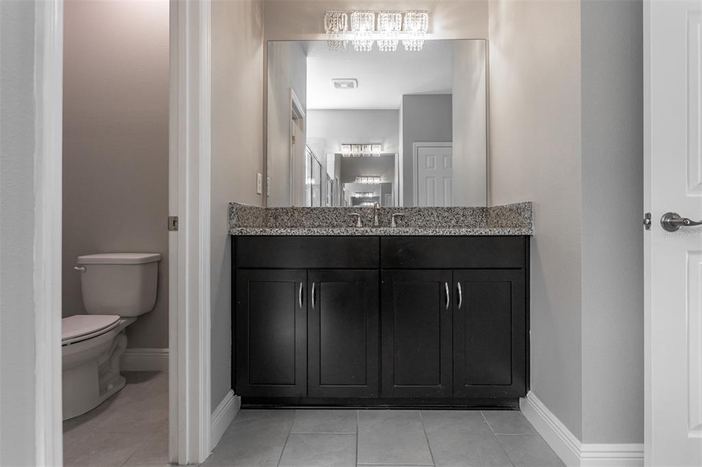 6906 Paradiso Drive Apollo Beach, FL 33572 - Photo 19 of 37 a bathroom with a granite countertop sink and a toilet