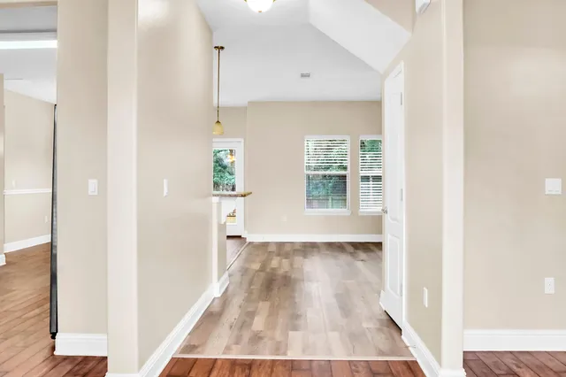 a view of a hallway with wooden floor and staircase