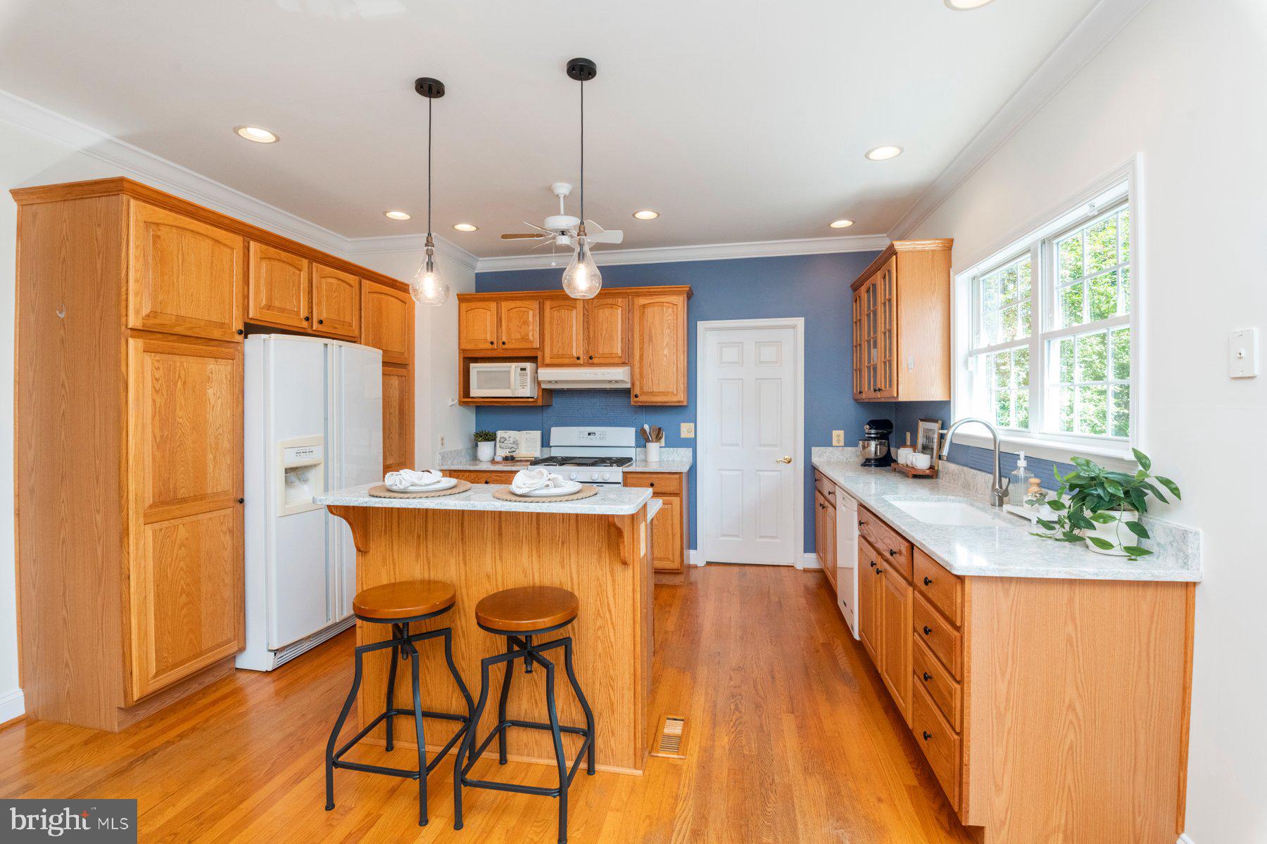 1012 Bernoudy Road White Hall, MD 21161 - Photo 7 of 28 a kitchen with stainless steel appliances granite countertop a refrigerator a sink dishwasher a stove and a dining table with wooden floor