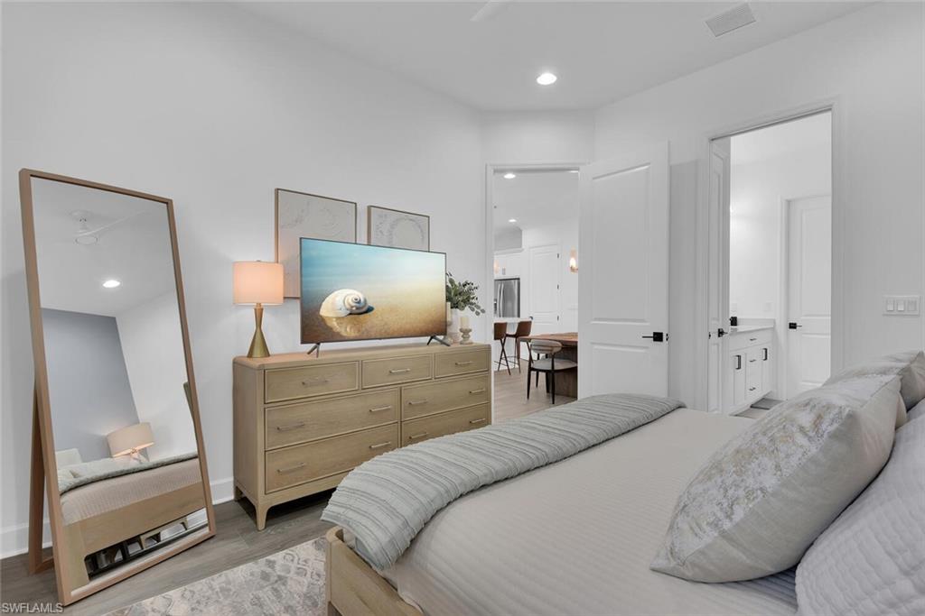 7242 Saona Court Naples, FL 34113 - Photo 13 of 34 a bedroom with a bed and a mirror